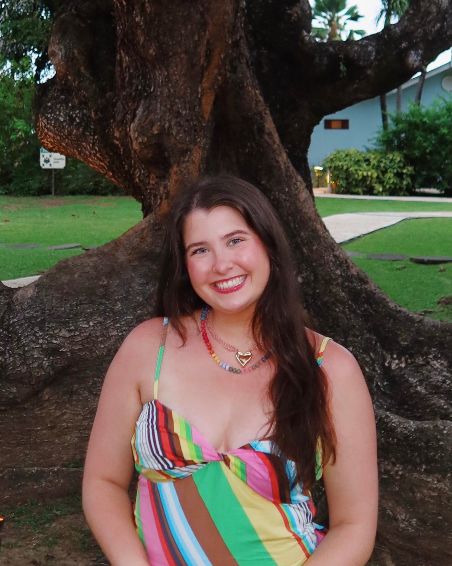 Bailee, founder of The Fancy Collective, smiling outdoors beneath a large tree.