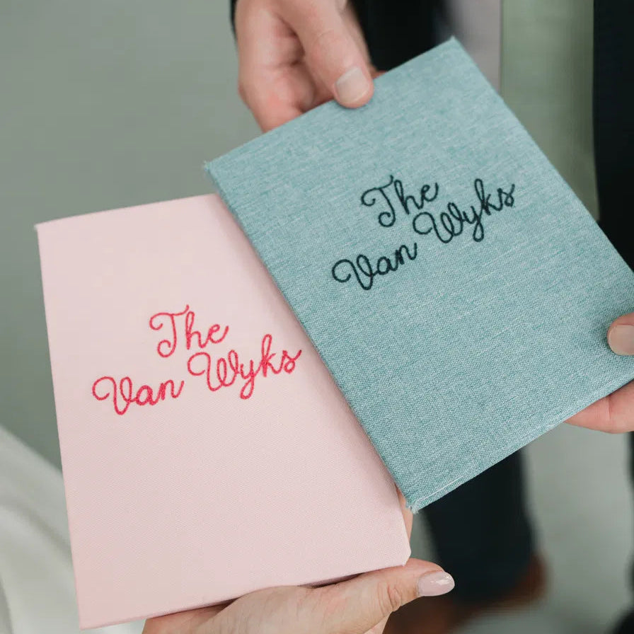 Custom linen wedding vow books personalized with the couple’s last name, designed to hold handwritten wedding vows.