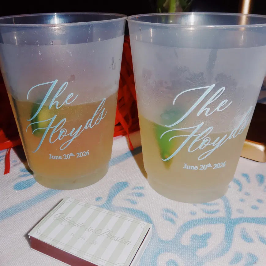 Custom frosted wedding cups featuring the couple’s name and wedding date, displayed with signature cocktails at a wedding reception.
