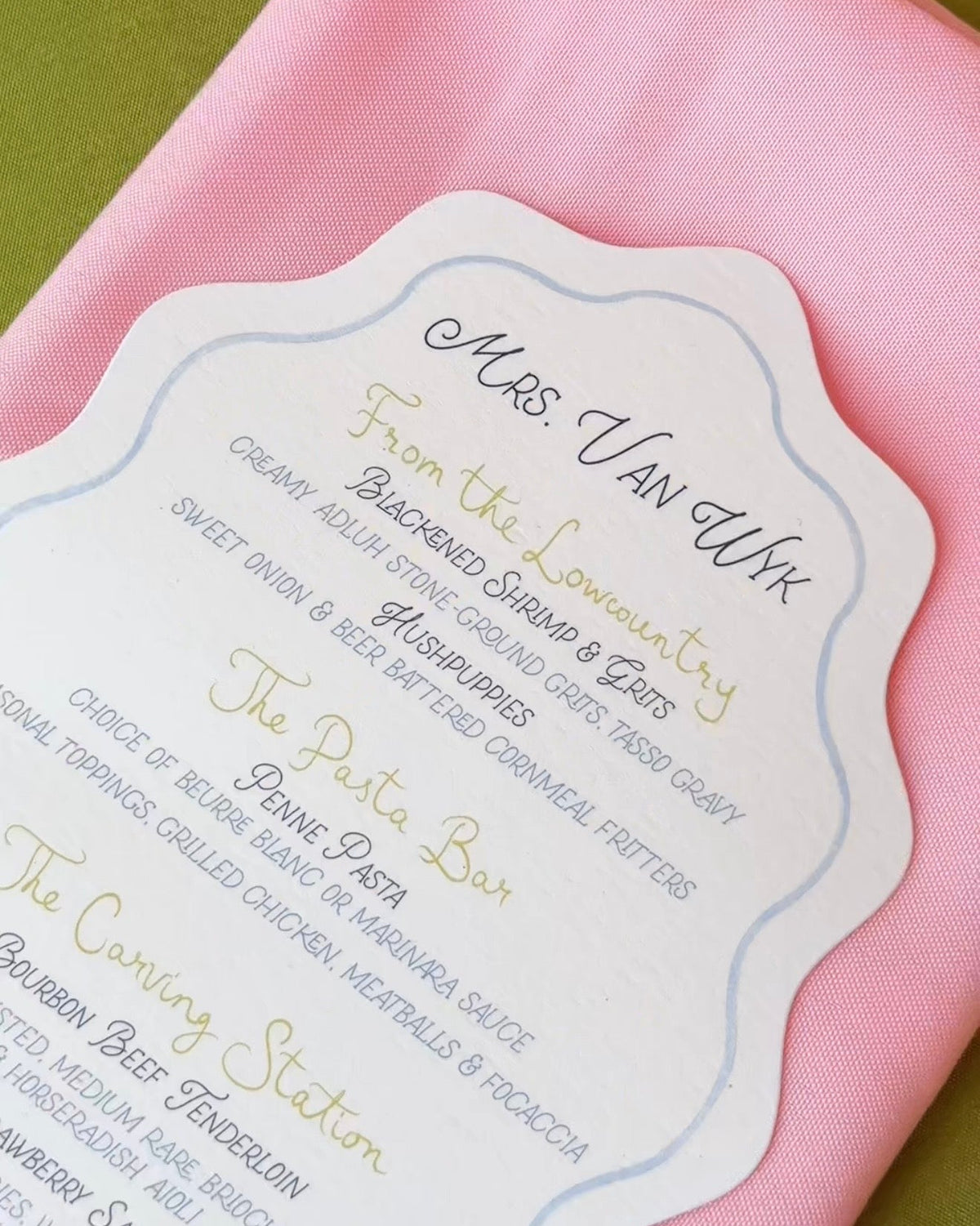 Custom scalloped wedding menu card featuring elegant typography and a personalized reception menu for a wedding celebration.