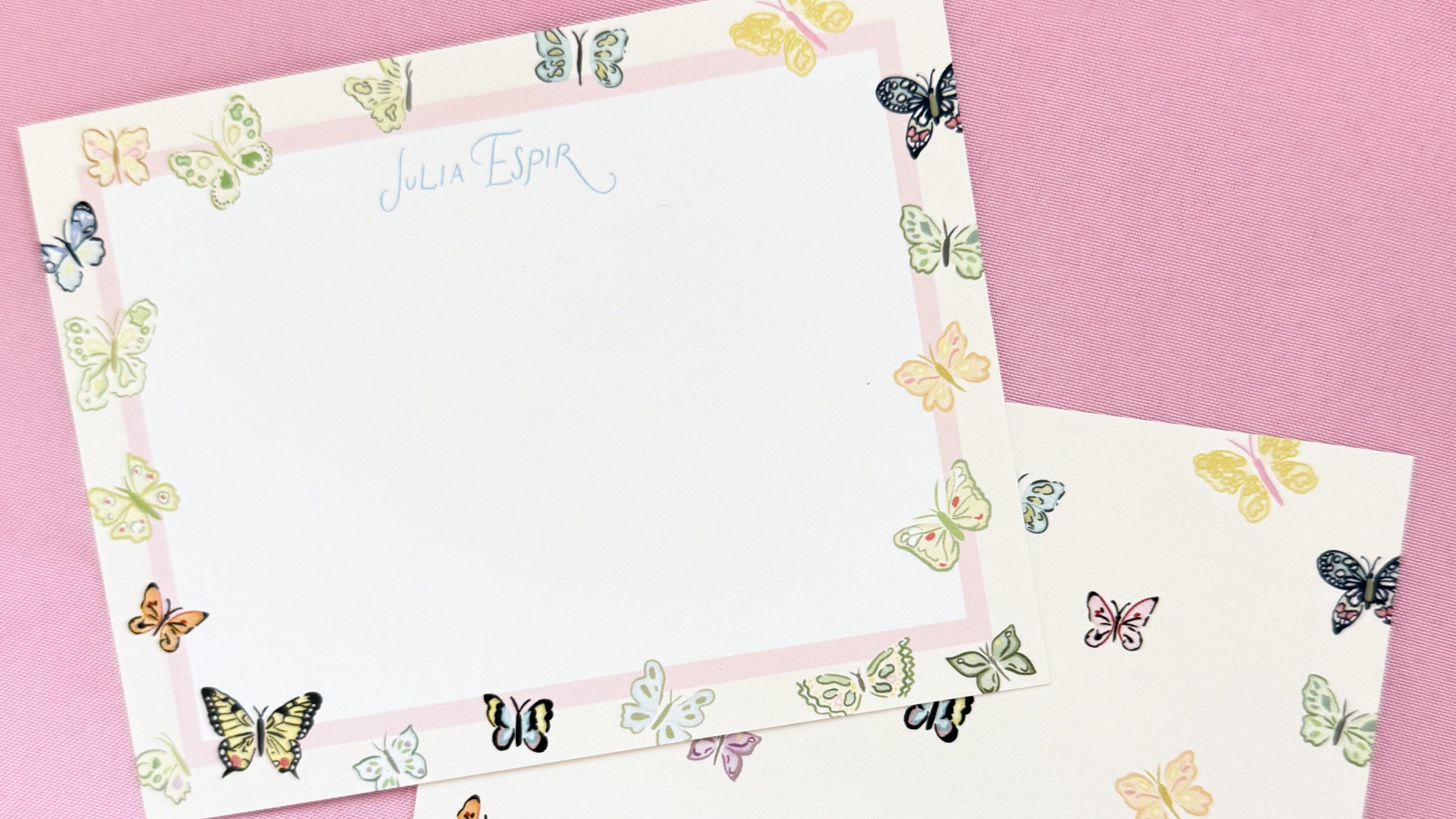Personalized stationery set featuring custom flat notecards with a colorful butterfly border and matching envelopes.
